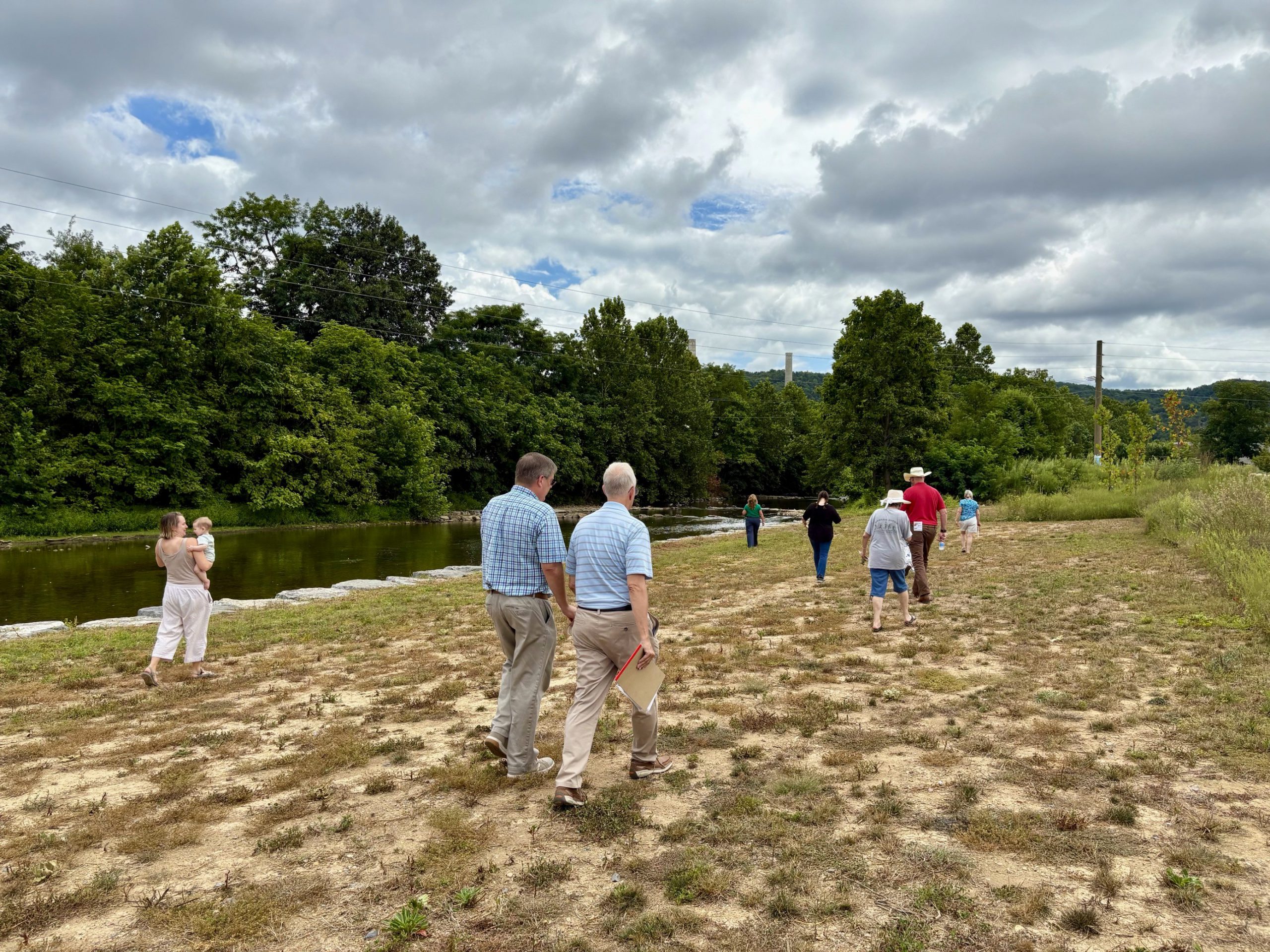 Image of attendees walking alongside the south river at the dedication event